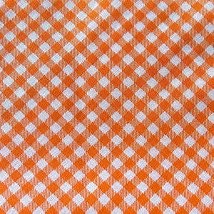 May include: Orange and white checkered fabric with a repeating pattern of squares.