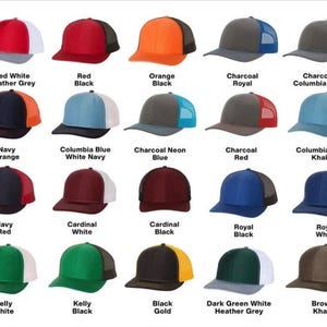 May include: A collection of trucker hats in various colors, including red, orange, blue, and green. Each hat features a mesh back and a solid front panel. The hats are displayed with color names like "Red White Heather Grey" and "Royal Black".