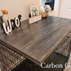 May include: A black metal dog crate with a wooden top painted in a carbon grey colour. The top has a sign that says "Forever in my heart" and the word "woof" is spelled out in white letters on the top.