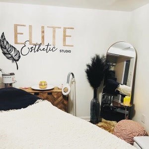 Custom laser-cut wooden business logo sign with detailed design, showcasing a natural wood finish and raised lettering for a professional, elegant look