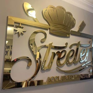 Elegant custom laser-cut business logo sign with raised 3D letters, featuring a durable gold mirror acrylic finish, providing a stunning reflective surface perfect for professional displays.