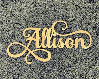 May include: A wooden sign with the name "Allison" written in a cursive script. The sign is painted gold and has a decorative flourish.