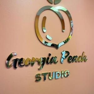 Custom laser-cut business logo sign with raised 3D lettering, featuring a luxurious mirror finish in gold, silver, or rose gold, ideal for professional branding with a sleek and reflective appearance