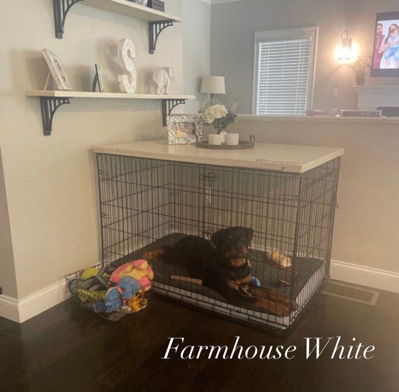 May include: A black metal dog crate with a white top and a black dog inside. The crate is sitting on a wooden floor. The text "Farmhouse White" is written below the crate.