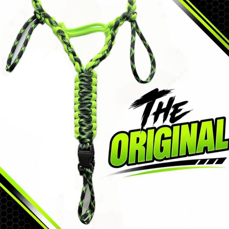 Pu&ograve; includere: Un cordino in paracord con un motivo intrecciato nero e verde neon, dotato di una fibbia centrale in plastica nera. Il design include molteplici anelli e una struttura a forma di Y. Il testo THE ORIGINAL &egrave; visualizzato in grandi lettere verdi e nere.