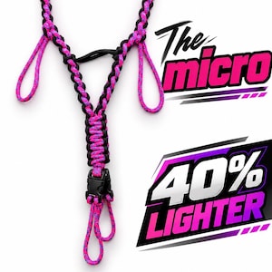 Può includere: Un cordino in paracord intrecciato con un motivo nero e rosa neon, dotato di tre anelli e una fibbia in plastica nera. Il testo "The micro" e "40% LIGHTER" è visualizzato in grassetto rosa e bianco sul lato destro dell'immagine.