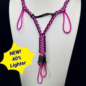 May include: A black and pink braided lanyard with a black clasp and pink and blue accents. The lanyard is displayed on a white mannequin. Text on the image reads "NEW! 40% Lighter."