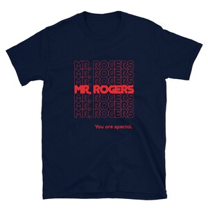 May include: Navy blue t-shirt with a repeated pattern of the text "MR. ROGERS" in red. The text "You are special." is printed below the pattern.
