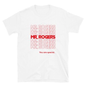 May include: White t-shirt with a red graphic print of the phrase "MR. ROGERS" repeated multiple times. The text "You are special." is printed below the graphic.