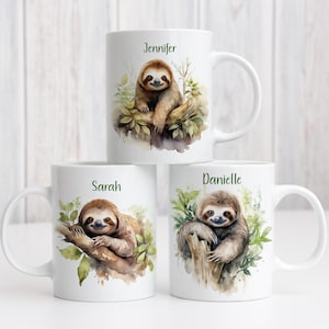 May include: Three white ceramic mugs with sloth illustrations. Each mug has a different name: Jennifer, Sarah, and Danielle. The sloths are painted on branches with green leaves. The mugs are ideal for hot beverages.