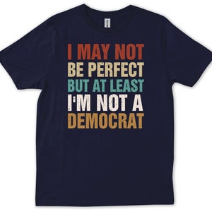 May include: Navy blue t-shirt with a vintage-style graphic that reads "I may not be perfect but at least I'm not a Democrat".