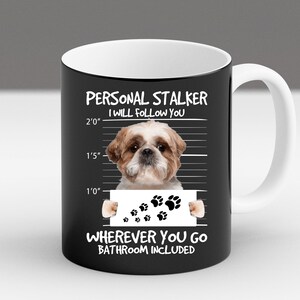 May include: Black ceramic mug with a white interior and handle. The mug features a white graphic of a Shih Tzu dog with the text "PERSONAL STALKER I WILL FOLLOW YOU WHEREVER YOU GO BATHROOM INCLUDED".