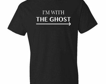 May include: Black t-shirt with the white text "I'M WITH THE GHOST" above a horizontal arrow pointing right. The shirt is a short-sleeved crew neck style.