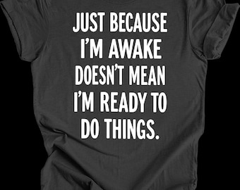 May include: Dark gray t-shirt with white text that reads "Just because I'm awake doesn't mean I'm ready to do things."