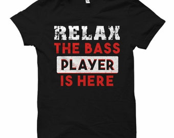 Puede incluir: Camiseta negra con texto blanco que dice "Relax the Bass Player is Here" en una fuente desgastada.
