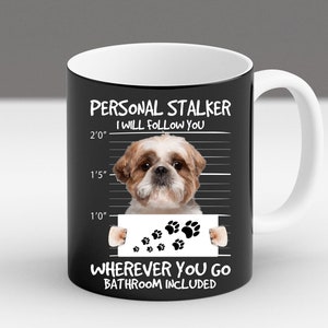 May include: A black mug with a white rim and handle. The mug features a cartoon image of a Shih Tzu dog with the text "PERSONAL STALKER I WILL FOLLOW YOU WHEREVER YOU GO BATHROOM INCLUDED".