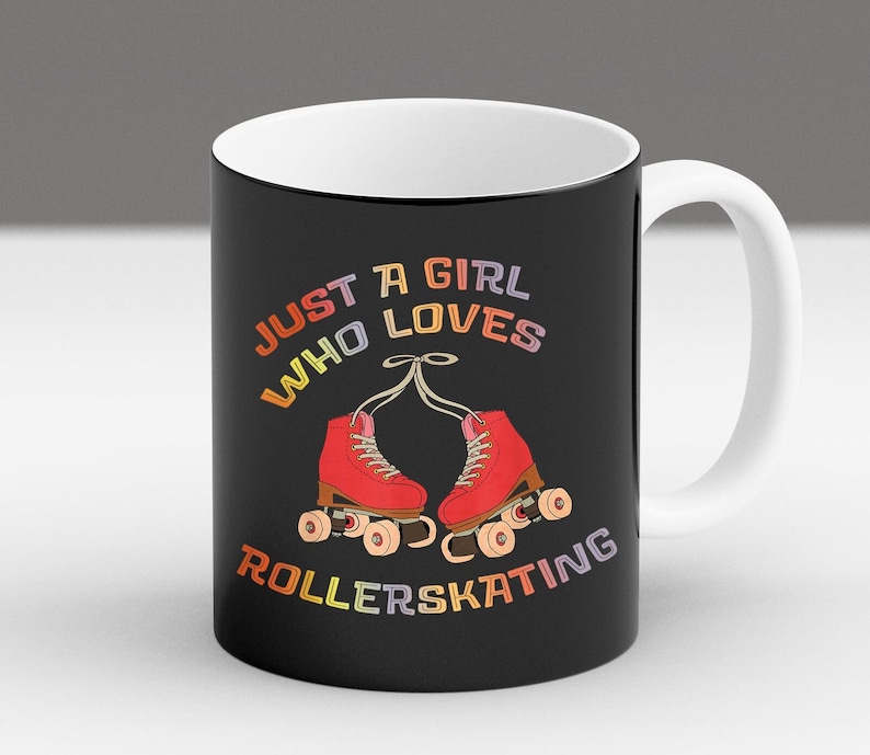May include: Black coffee mug with a white rim and handle. The mug features a colorful graphic of roller skates and the text "Just a girl who loves rollerskating".