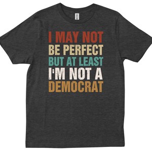 May include: Dark grey t-shirt with a vintage-style graphic that reads "I may not be perfect but at least I'm not a Democrat".