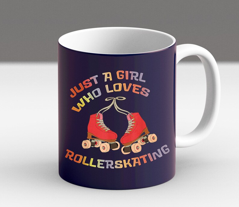 May include: A white ceramic mug with a navy blue design. The mug features a pair of red roller skates with rainbow colored wheels and the text "Just a girl who loves rollerskating".
