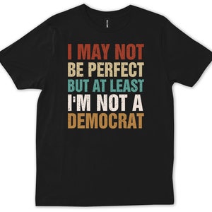 May include: Black t-shirt with a vintage-style graphic that reads "I may not be perfect but at least I'm not a Democrat".