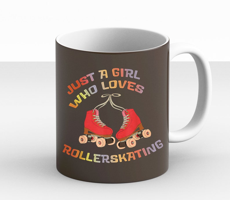 May include: A brown ceramic mug with a white handle. The mug has a graphic of a pair of roller skates with the text "Just a girl who loves rollerskating" in rainbow colors.