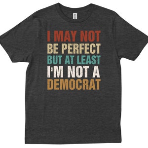 May include: Dark gray t-shirt with a vintage-style graphic that reads "I may not be perfect but at least I'm not a Democrat".