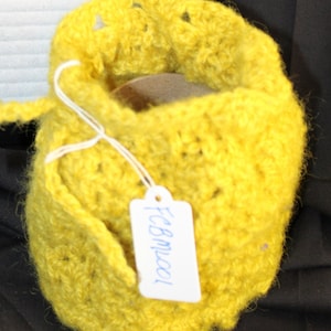 May include: A yellow crocheted pouch with a white tag that says "Fcbwool".