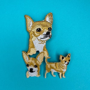 May include: Three embroidered chihuahua patches in brown and white. The patches are on a blue background.