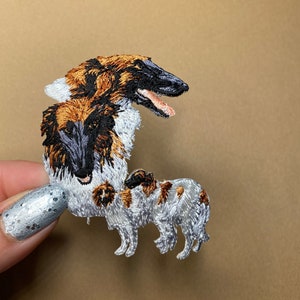 May include: Embroidered patch featuring a brown and white Borzoi dog breed. The patch is made of fabric and has a detailed design.