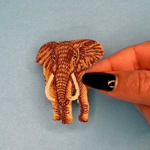 Peut inclure: Patch brodé en forme d'éléphant brun avec des défenses blanches. Le patch est parfait pour ajouter une touche de fantaisie aux vêtements, aux sacs ou à d'autres accessoires.