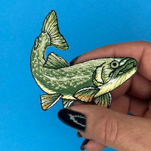 May include: Green and yellow embroidered iron-on patch of a fish with a fin and tail.