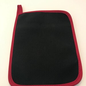 Peut inclure: Un porte-pot en noir avec une bordure rouge. Le porte-pot a une poign&eacute;e en boucle.