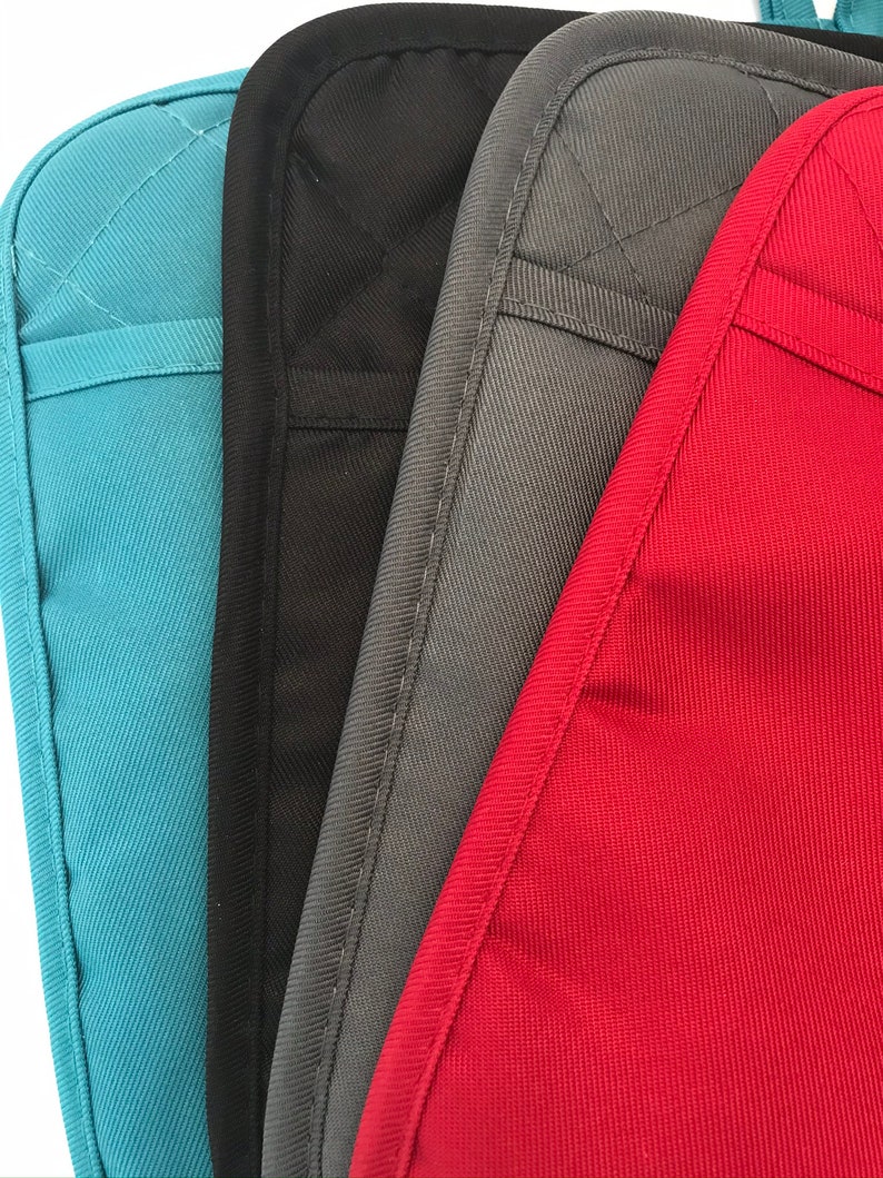 Peut inclure: Quatre maniques de diff&eacute;rentes couleurs&nbsp;: sarcelle, noir, gris et rouge. Les maniques sont en tissu matelass&eacute; avec un motif en losange.