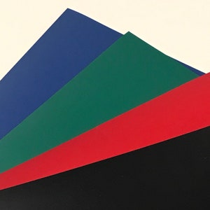 Peut inclure: Quatre feuilles de papier empil&eacute;es les unes sur les autres. La feuille du dessus est bleue, la deuxi&egrave;me feuille est verte, la troisi&egrave;me feuille est rouge et la feuille du dessous est noire.
