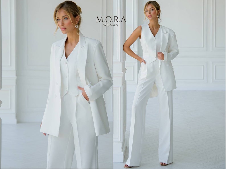 Puede incluir: Un traje de pantal&oacute;n blanco con una chaqueta, un chaleco y pantalones de pierna ancha. El traje est&aacute; hecho de una tela suave y tiene un corte cl&aacute;sico y entallado. La modelo lleva el traje con una blusa blanca debajo.