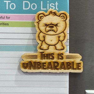 May include: Wooden magnet featuring a cartoon bear and the text "This is Unbearable".