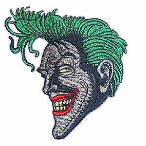 May include: A green-haired, grinning joker with a wide, toothy smile. The joker's face is grey and the hair is a bright green.