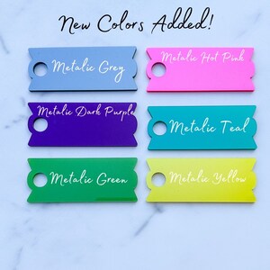Pu&ograve; includere: Sei campioni di colore con un foro al centro. I colori sono grigio metallizzato, rosa acceso, viola scuro, verde acqua, verde e giallo.