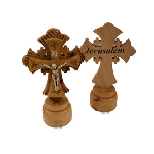 May include: Two wooden crosses, one with a silver crucifix and the other with the word "Jerusalem" carved into it. Both crosses are on small wooden bases.