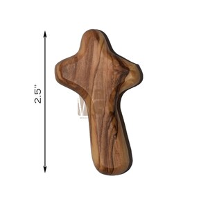 May include: A 2.5 inch olive wood cross with a simple design. The cross is made of natural wood with a rich brown color and intricate grain patterns.