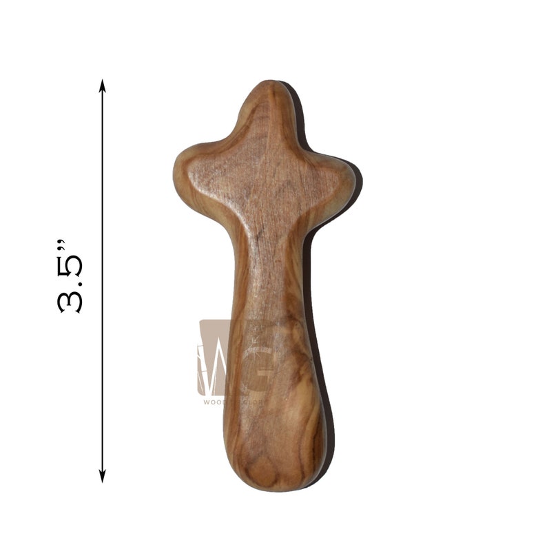 May include: A small, wooden cross made of olive wood. It is 3.5 inches tall and has a simple, rounded shape.