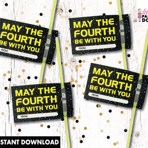 May include: Four black and yellow "May the Fourth Be With You" gift tags with a lightsaber design. The tags have a white space for "From:" and are surrounded by gold and black confetti.