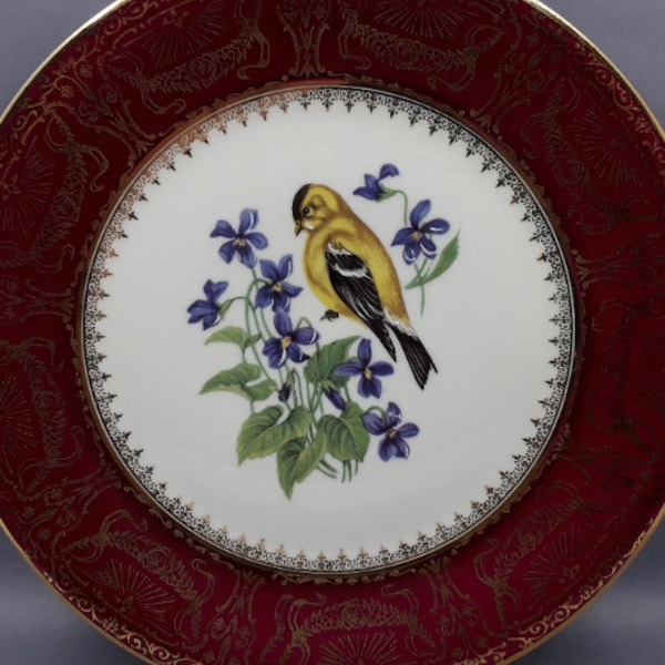 Assiette de collection, en porcelaine de Limoges, A. Vignaud, à décor d’un oiseau et bouquet de violettes, frise or au pourtour, 1950-1960