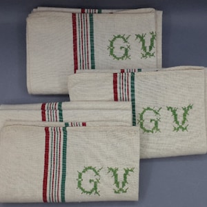 Può includere: Un set di sei asciugamani da tè in lino bianco con strisce verdi e rosse e le iniziali "GV" ricamate in verde.