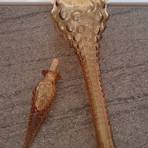 Pode incluir: Um conjunto de dois decantadores de vidro &acirc;mbar com um design texturizado em forma de bolhas. O decantador maior tem uma parte superior redonda e um pesco&ccedil;o longo e fino. O decantador menor &eacute; um tamp&atilde;o para o decantador maior.