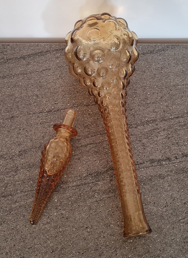 Pode incluir: Um conjunto de dois decantadores de vidro &acirc;mbar com um design texturizado em forma de bolhas. O decantador maior tem uma parte superior redonda e um pesco&ccedil;o longo e fino. O decantador menor &eacute; um tamp&atilde;o para o decantador maior.