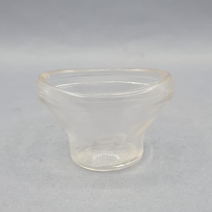 May include: A clear glass dish with a rounded bottom and a slightly flared rim.