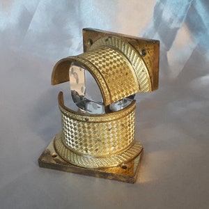 Könnte beinhalten: Ein Satz aus drei goldfarbenen Metallkonsolen mit einem dekorativen, gemusterten Design. Die Konsolen sind für die Verwendung als Regalstützen konzipiert.