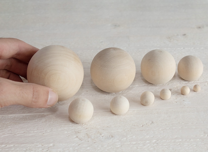 May include: A set of ten wooden balls of varying sizes, ranging from small to large. The balls are all natural wood color and have a smooth, polished finish.