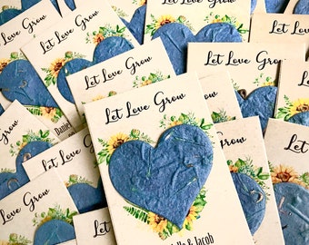 May include: A stack of white cards with blue paper hearts and sunflower illustrations. The cards have the text "Let Love Grow" printed on them. The text "Danielle & Jacob" is printed on the bottom of one card.